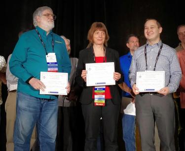 Illinois CS Teaching Assistant Professor Geoffrey Herman, right, accepts the award from SIGCSE with two of his co-authors, Assistant Professor Philip East of Northern Iowa University and education consultant and Harvey Mudd College instructor Lisa C. Kaczmarczyk.