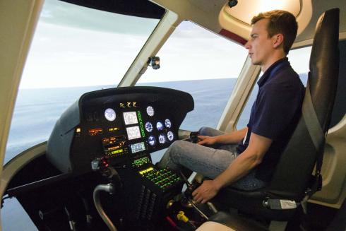 Chris Frost (BS, Aerospace Engineering, 2010) takes an AS 350 simulator for a virtual flight. He and his team are responsible for the flight and engine model and reactions to terrain.