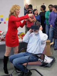Anna Yershova, a CS alumna and Oculus research scientist helps CS Professor Gerald DeJong try out the Oculus Rift HD prototype.