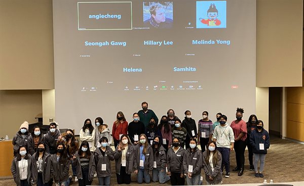 High School students who attended 2021 ChicTech event at Illinois CS, pose in front of a projector's screen showing others who attended the event digitally.