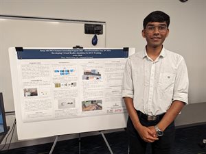 Arnav Shah stands in front of his research poster.