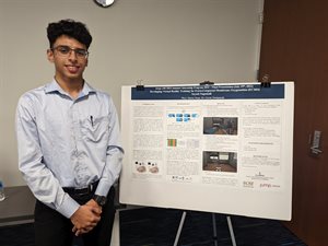 Suyash Nagumalli stands in front of his research poster.