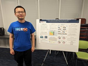 Zijun Yu stands in front of his research poster.