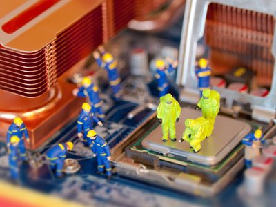 Tiny toy people in blue and florescent yellow suits investigate and repair a semiconductor computer chip.
